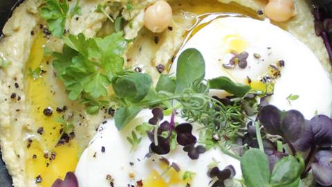 Mediterrane Frühstückseier auf cremigen Hummus mit Kräutern